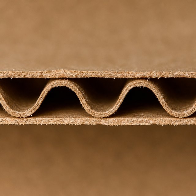Cut edge of E-flute corrugated board showing the fluted core between two liners