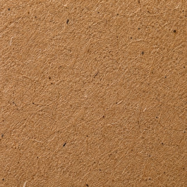 Close-up of unbleached kraft board surface with visible fibre flecks
